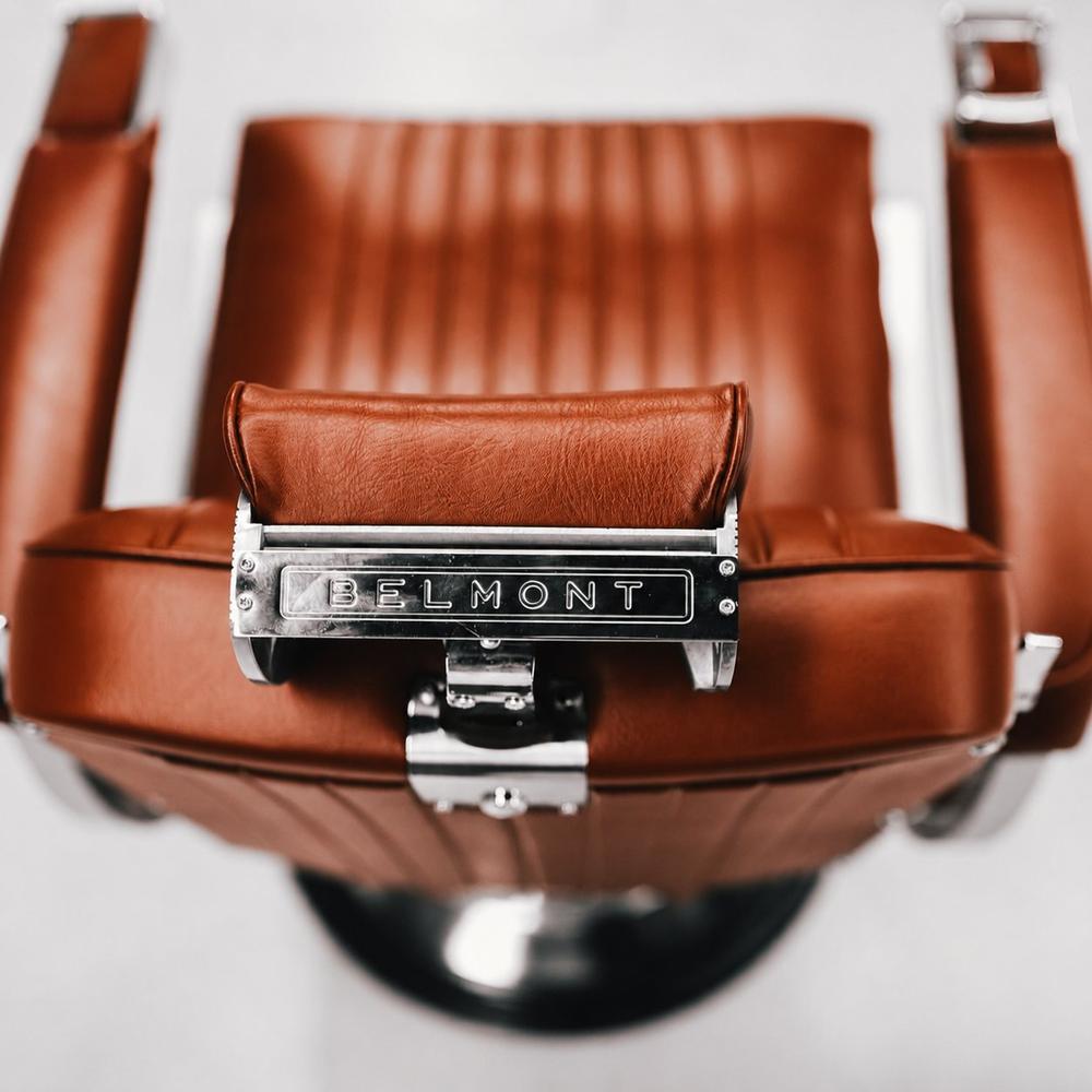 Close-up of burnt orange Belmont barber chair leather with chrome detailing